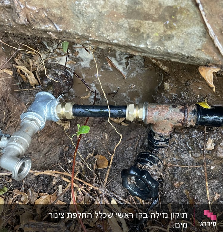 ברז מתכת עם צינור מחובר באדמה רטובה